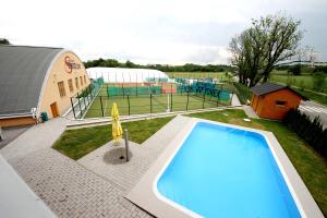 a large swimming pool with a tennis court in the background at Hotel S-centrum in Benešov