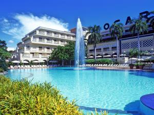吉拉爾的住宿－託卡勒瑪酒店，一座大楼前的游泳池,带喷泉
