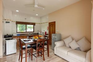 a kitchen and living room with a table and a couch at Stone Self Catering Apartment in Grand'Anse Praslin
