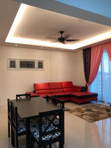 een woonkamer met een rode bank en een tafel bij KJ Homestay Casa Kayangan in Ipoh