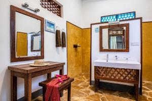 ein Badezimmer mit Waschbecken und Spiegel in der Unterkunft Pongwe Beach Hotel in Pongwe