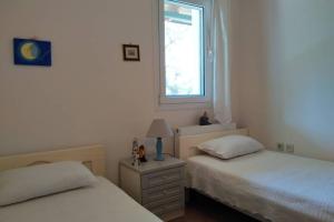 sypialnia z 2 łóżkami i oknem w obiekcie Fiorela maisonette w mieście Sami