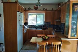 a kitchen with wooden cabinets and a table with a bowl of fruit on it at Fiorela maisonette in Sami