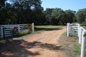 un camino de tierra con una valla y una señal en él en Sapphire Chalets, Augusta, en Augusta