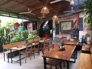 a restaurant with wooden tables and chairs and plants at SOVANN'S HOUSE By Uncle's House in Siem Reap