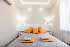 a bedroom with a bed with orange pillows at Hamlet Old Town Apartment by TriApart in Gdańsk