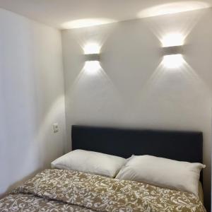 1 Schlafzimmer mit 2 Leuchten über einem Bett in der Unterkunft Superbe studio rue piétonne principale Sanary à côté du port in Sanary-sur-Mer