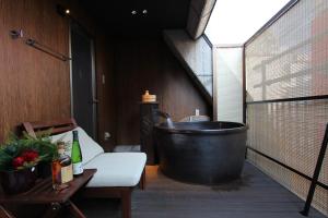 a large bath tub sitting on a deck with a table at Konjaku-So Dotonbori Garden SPA Stay in Osaka