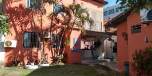 un bâtiment rose avec des palmiers devant lui dans l'établissement Pousada Suites das Galinhas, à Porto de Galinhas
