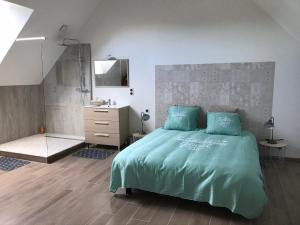 1 dormitorio con cama, lavabo y espejo en LE CHARME D OGNES, en Ognes