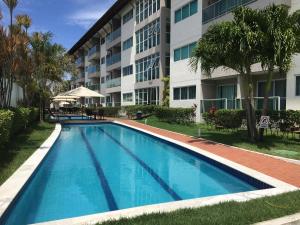a swimming pool in front of a building at Porto Plaza Flat - 404 in Porto De Galinhas