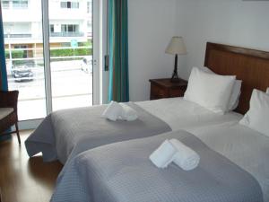 2 Betten in einem Hotelzimmer mit Handtüchern darauf in der Unterkunft Riviera Flat in Portimão