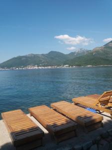 un gruppo di letti in legno posti sull'acqua di Apartments Olga a Tivat