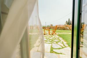 una ventana con vistas a un patio con mesa y sillas en Cunda Esen Hotel, en Ayvalık