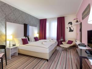 A bed or beds in a room at Mercure Hotel Wiesbaden City