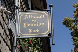 una señal para un restaurante al lado de un edificio en Altstadt-Pension Koch en Goslar