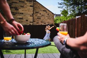 Eine Gruppe von Leuten, die mit einem kleinen Mädchen am Tisch sitzen. in der Unterkunft Listers Lodge in Halifax + 18 Fotos