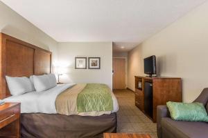 a hotel room with a bed and a flat screen tv at Quality Inn Summerville-Charleston in Summerville +16 photos