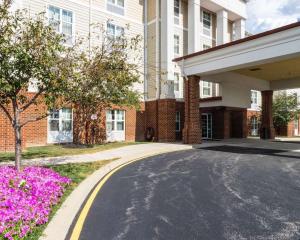 a street in front of a building with pink flowers at Mainstay Suites Dover in Dover