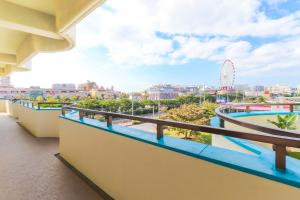 balcón con vistas a un parque de atracciones en Condominium Hotel Mihama Upi, en Chatan