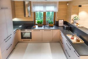 a kitchen with white cabinets and a sink and a window at Gruszowa Villa in Kalwaria Pacławska