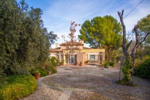 an exterior view of a house with a garden at Cigarral Valdecolomba in Toledo