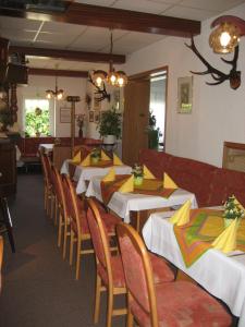 a dining room with tables and chairs with yellow napkins at Hotel Kirchner in Tharandt