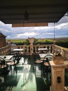 a restaurant with tables and chairs on a balcony at Hotel Ficocle in Cervia