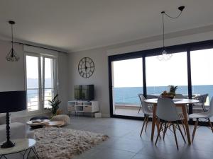 ein Wohnzimmer mit einem Tisch, Stühlen und Meerblick in der Unterkunft Apartments4friends Apartment NINA in Slatine