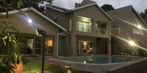 una casa grande con piscina frente a ella en DeTlous BnB, en Empangeni