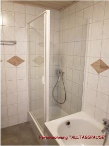 uma casa de banho com um chuveiro e uma banheira com uma porta de vidro em Das Altstadthaus em Volkach