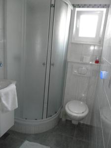 La salle de bains est pourvue d'une douche, de toilettes et d'une fenêtre. dans l'établissement Apartments Rinčić, à Marina