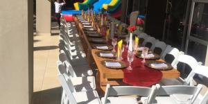 a long wooden table with white chairs around it at DeTlous BnB in Empangeni