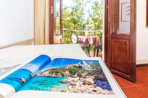 un libro su un letto con vista sull'oceano di Hotel Santa Maria a Santa Maria Navarrese