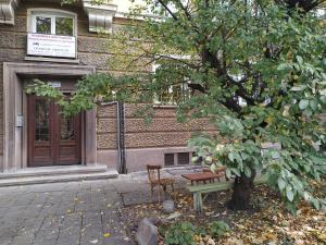 a bench next to a tree in front of a building at COLORED HOUSE Apartments in Sofia