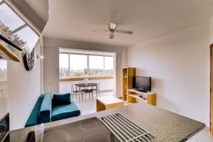 un soggiorno con divano blu e TV di Hope House - 1 Bedroom - Vilamoura a Vilamoura