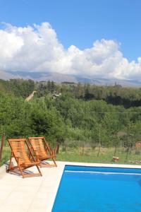 un par de sillas sentadas junto a una piscina en Libertad en Villa Yacanto