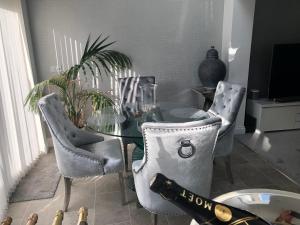 a dining room with a glass table and chairs at Jonan House in Deal