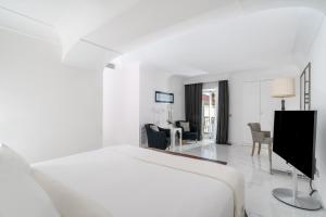 a white bedroom with a bed and a living room at Hotel Villa Franca in Positano
