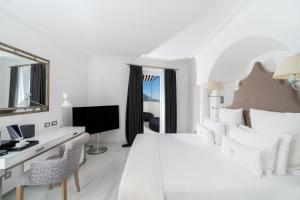 a hotel room with white walls and white furniture at Hotel Villa Franca in Positano