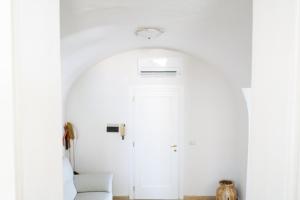 a white room with a white door and a chair at Casa Cardi in Sperlonga