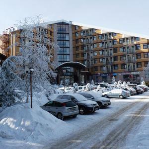 a parking lot filled with cars covered in snow at Flora Apartments TMF in Borovets