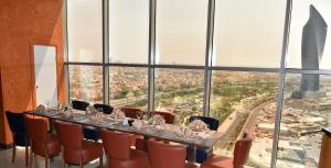 a long table in a room with a view of a city at Ramada Encore by Wyndham Kuwait Downtown in Kuwait