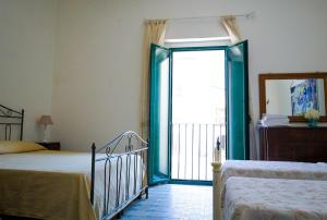 a bedroom with two beds and a sliding glass door at Casa Cardi in Sperlonga