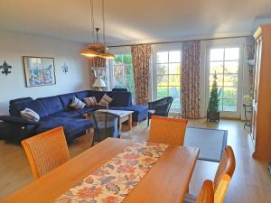 a living room with a blue couch and a table at Reethaus Zickersche Berge - Apt. 01 in Gager +32 photos