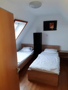 two beds in a room with a window at Apartment Öffingen 77 in Fellbach