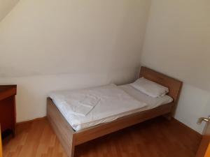 uma pequena cama num quarto com paredes brancas em Apartment Öffingen 77 em Fellbach
