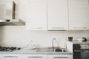 a kitchen with white cabinets and a sink at Casa Cardi in Sperlonga