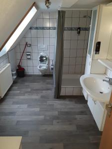 a bathroom with a sink and a tub and a toilet at Apartment Öffingen 77 in Fellbach