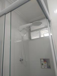 een douche met een douchekop in een badkamer bij Quarto com café nas Pitangueiras in Guarujá +18 foto's